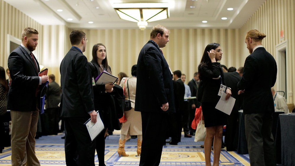 Attendees wait in line to speak with a prospective employer at a job fair on March 8, 2014.