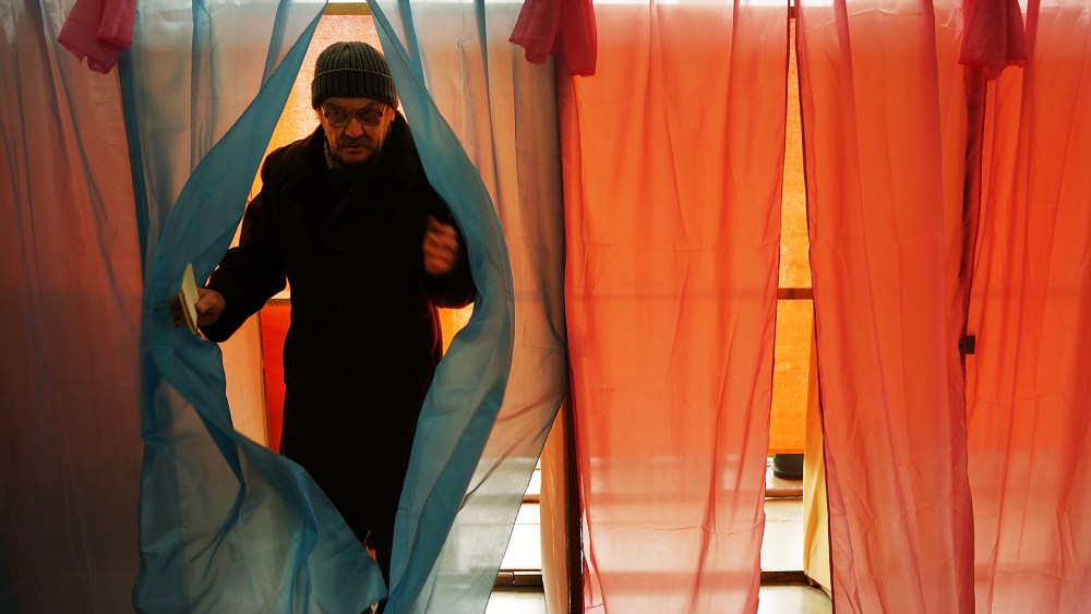 A man exits a polling booth with his ballot paper inside a polling station on March 16, 2014 in Perevevalne, Ukraine.