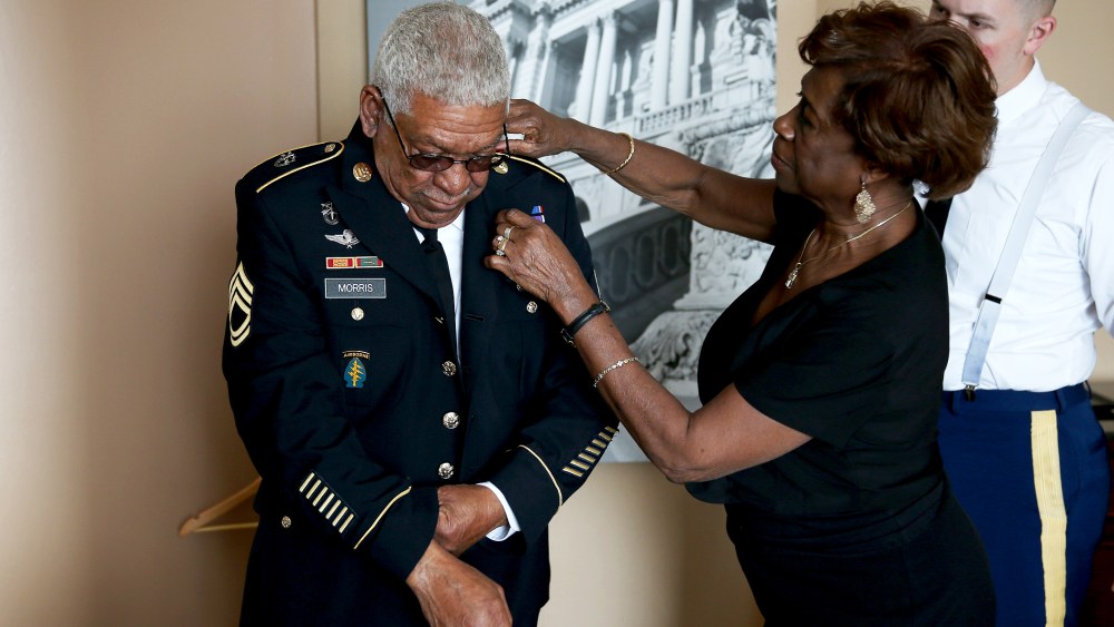 Mary Morris helps her husband U.S. Army Staff Sgt. (Ret.) Melvin Morris, a Vietnam War veteran, with his uniform as they prepare to make their to the White House on March 18, 2014.