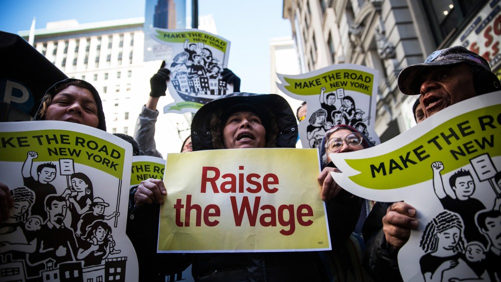 Women hold banners during a protest for higher wages for fast food workers on March 18, 2014 in New York, N.Y. (Photo by Andrew Burton/Getty)