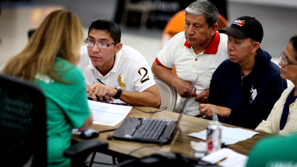 Paul Paucar (L-R), Homero Paucar, Giovanny Paucar and Ivonne Cucalon sit with Jessica Adames to purchase health insurance under the Affordable Care Act on March 20, 2014 in Miami, Fla.