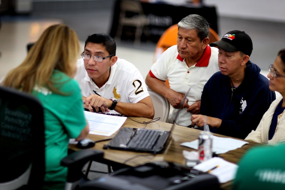 Paul Paucar (L-R), Homero Paucar, Giovanny Paucar and Ivonne Cucalon sit with Jessica Adames to purchase health insurance under the Affordable Care Act on March 20, 2014 in Miami, Fla.