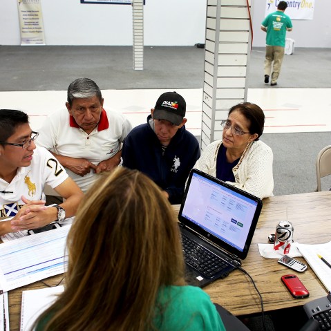 An insurance agent helps a family as they try to purchase health insurance under the Affordable Care Act in Miami, Florida, Mar. 20, 2014.