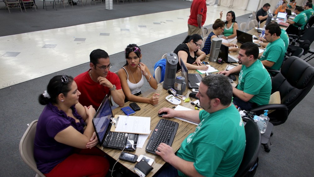 People try to purchase health insurance under the Affordable Care Act at a store setup in the Mall of Americas on March 20, 2014 in Miami, Florida.