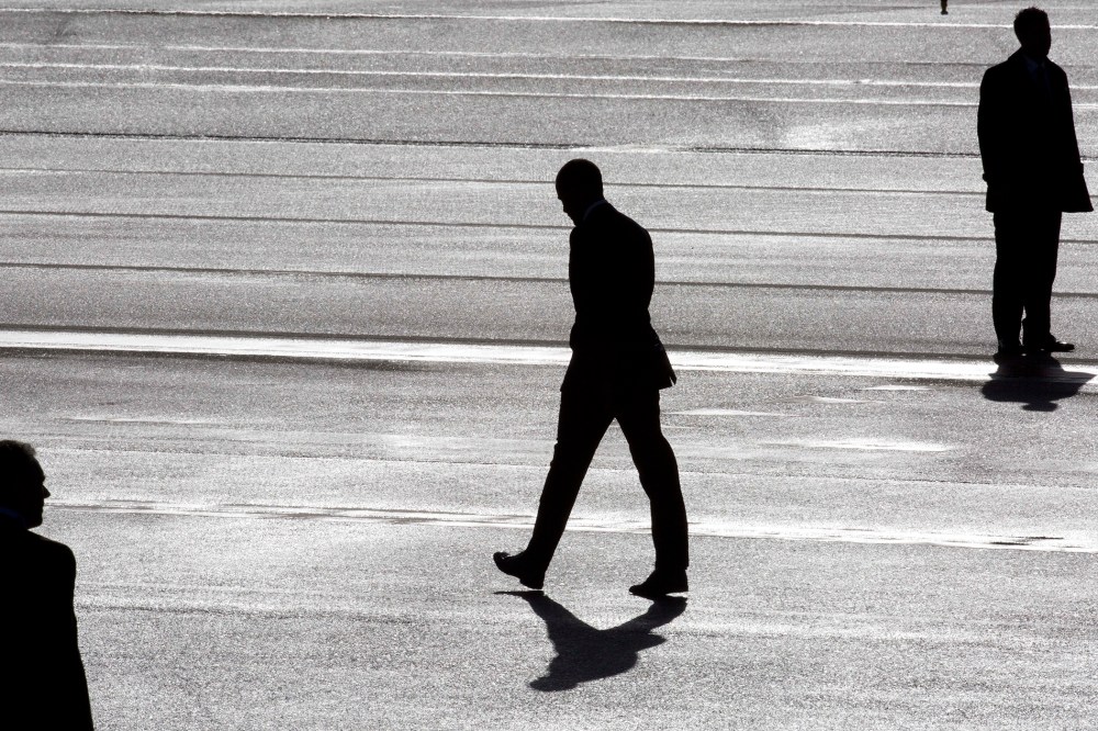 President Barack Obama (C) and two secret service agents are silhouetted as he walks towards Marine One helicopter as they arrive at Schiphol Amsterdam Airport