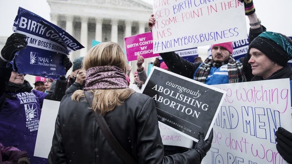 Activists with opposing views about contraceptive health care mix outside the Supreme Court in Washington, DC., Mar. 25, 2014.