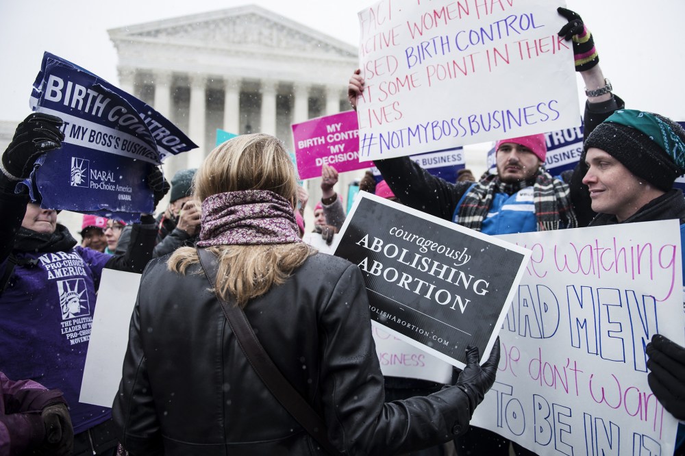 Activists with opposing views about contraceptive health care mix outside the Supreme Court in Washington, DC., Mar. 25, 2014.