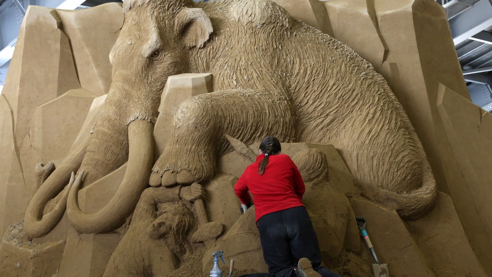 Karen Fralich of Canada finishes a sand sculpture at the Sand Museum in the Tottori Dune on April 3, 2014 in Tottori, Japan.