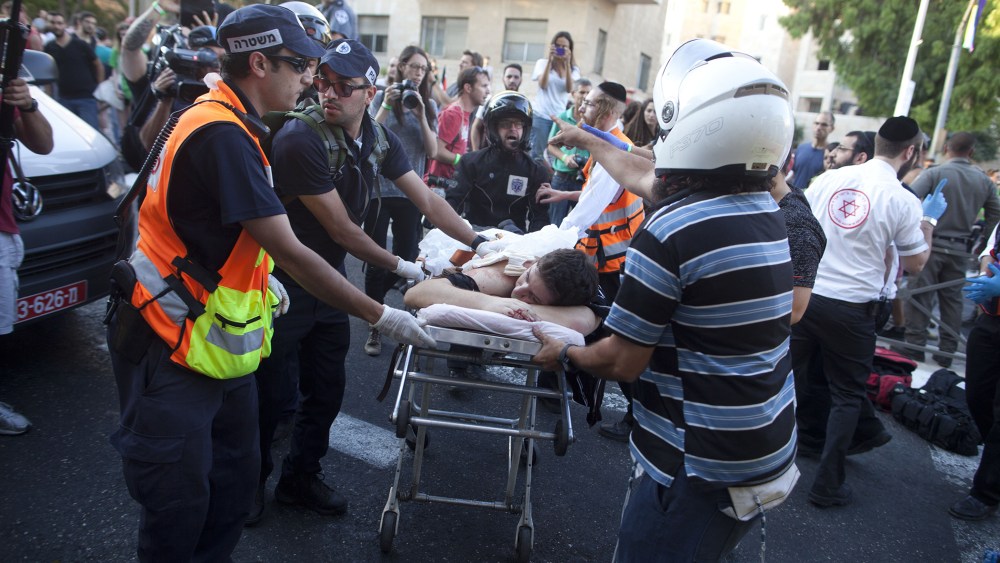 An wounded an Israeli man receives treatment during the Gay Pride Parade on July 30, 2015 in Jerusalem, Israel. (Photo by Lior Mizrahi/Getty)