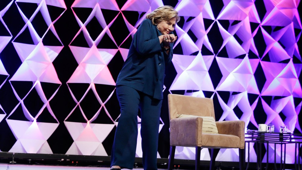 Former Secretary of State Hillary Clinton ducks after a woman threw an object toward her while she was delivering remarks in Las Vegas, April 10, 2014.