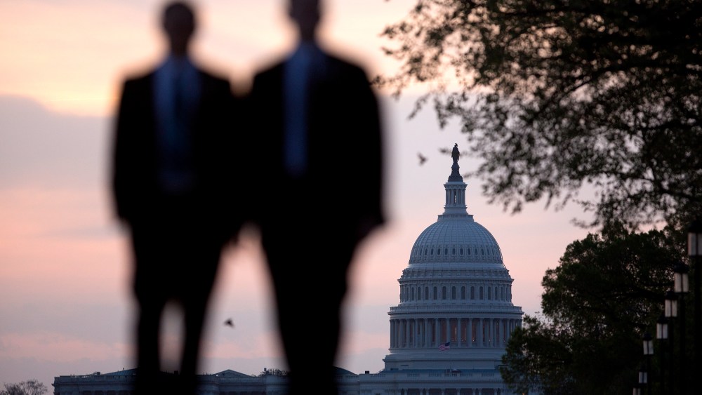 Men walk on the National Mall near the U.S. Capitol in Washington, D.C., U.S., on Monday, April 14, 2014