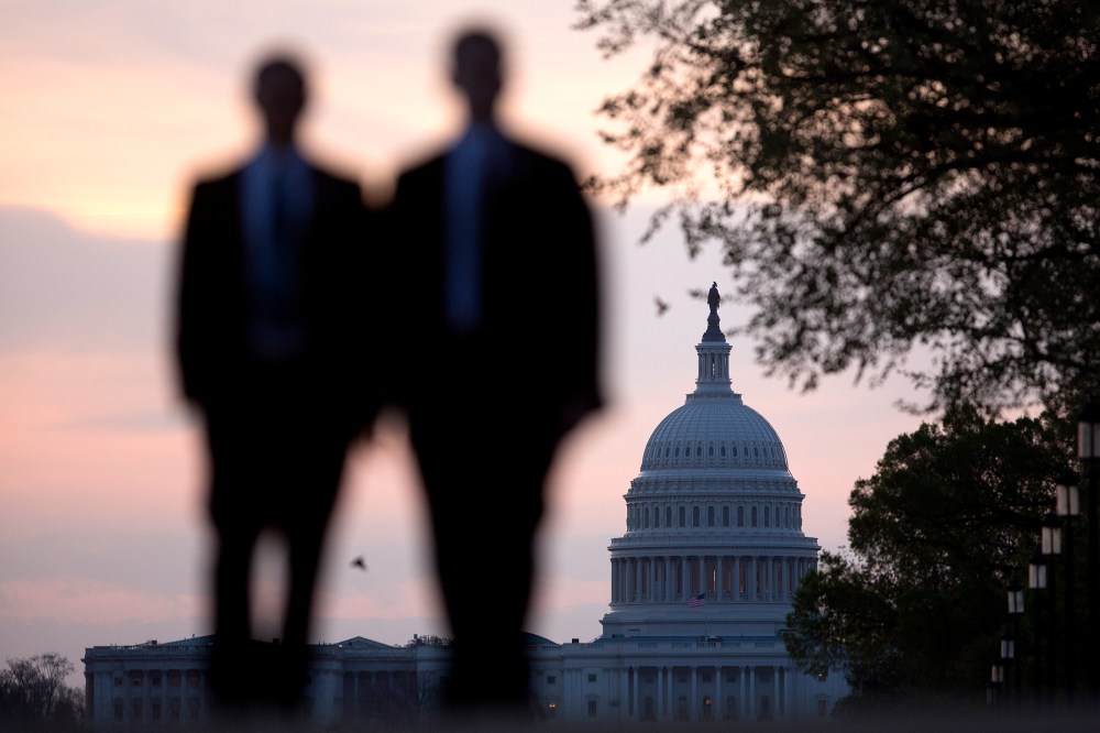 Men walk on the National Mall near the U.S. Capitol in Washington, D.C., U.S., on Monday, April 14, 2014