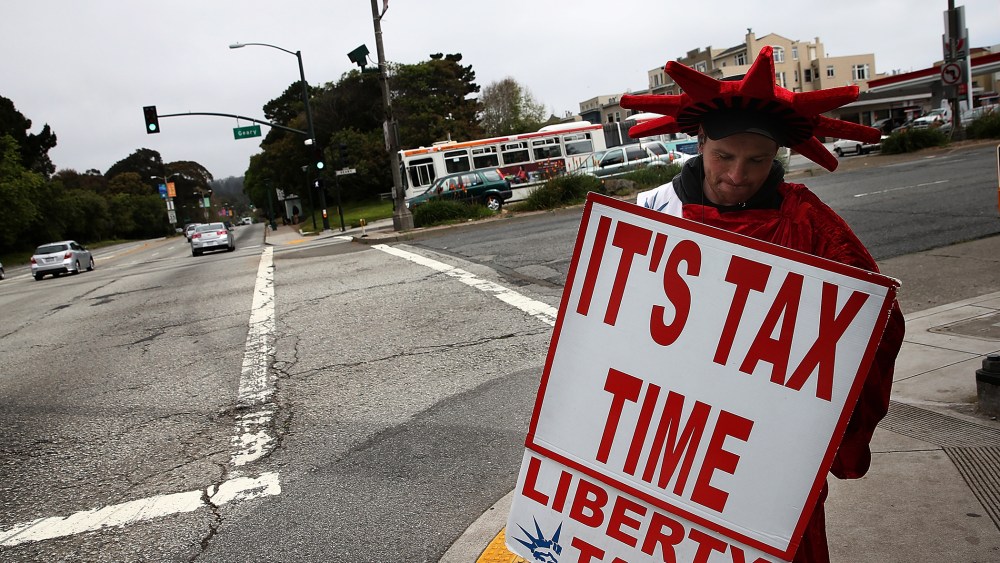 Aaron Lee holds a sign advertising income tax services for Liberty Tax Service on April 14, 2014 in San Francisco, California