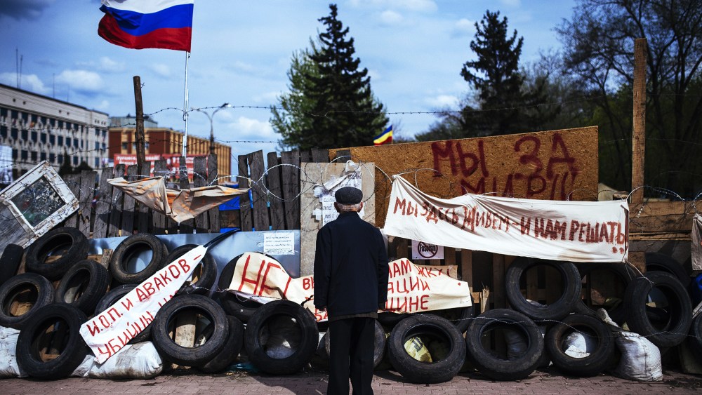 An elderly man stands next a barricade near the secret service building in the eastern Ukrainian city of Lugansk, April 22, 2014.