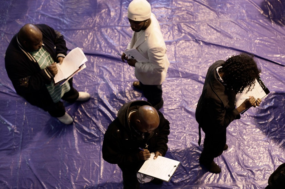 People seeking employment fill out applications at a job fair at the Matrix Center April 23, 2014 in Detroit, Michigan.