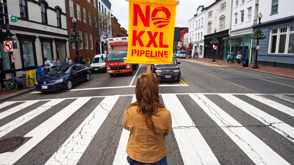 A protester holds an anti-Keystone XL sign at the intersection of Wisconsin and M Streets in Washington DC's Georgetown neighborhood, April 25, 2014.