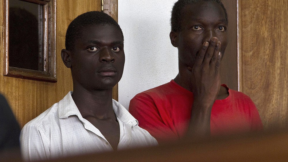 Two Ugandan men, Kim Mukisa (R) and Jackson Mukasa (L) appear before the Uganda Chief Magistrates Court in Kampala on May 7, 2014.