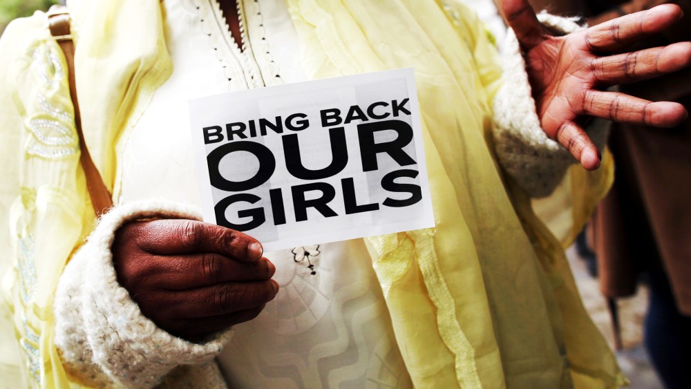 A woman holds a sign that reads 'Bring back our girls' during a protest.