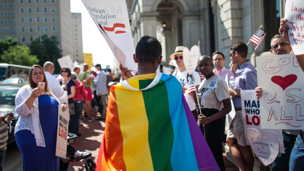 A same-sex marriage supporter wears a rainbow cape behind 4th U.S. Circuit Court of Appeals after a court hearing  May 13, 2014 in Richmond, Virginia.