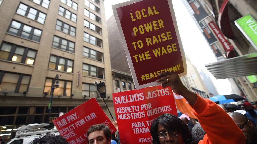 Fast-food workers hold placards in support to an increase of the fast food workers minimum wage in N.Y. on May 15, 2014. (Emmanuel Dunand/AFP/Getty)