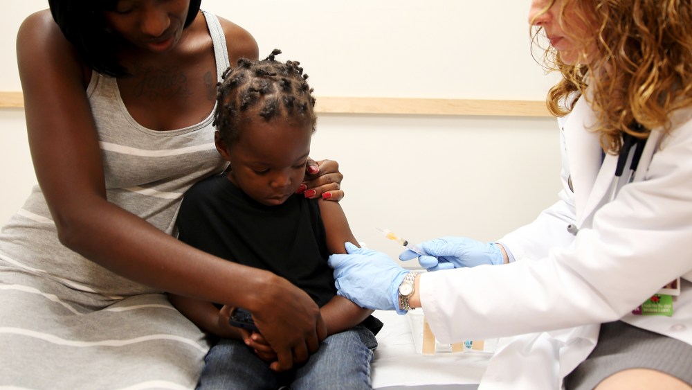 Shakeithia Roberts holds her son as a pediatrician administers a measles vaccination during a visit to the Miami Children's Hospital on May 16, 2014.