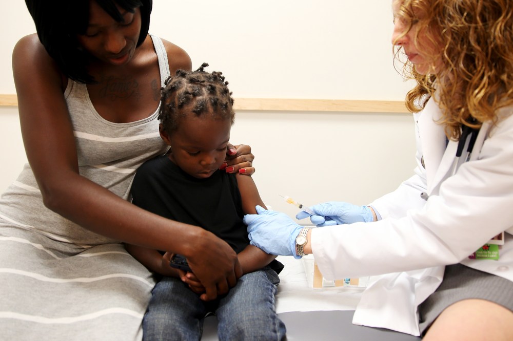 Shakeithia Roberts holds her son as a pediatrician administers a measles vaccination during a visit to the Miami Children's Hospital on May 16, 2014.