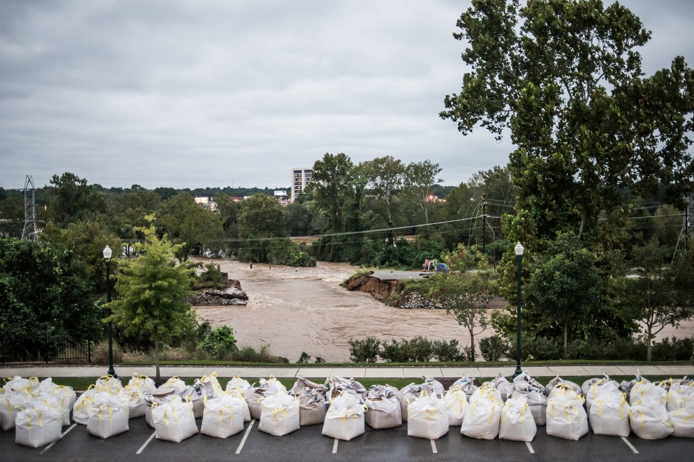 Flood waters rush through the breach of the Columbia Canal as emergency workers prepare giant sandbags to plug the hole on Oct. 5, 2015 in Columbia, S.C. (Photo by Sean Rayford/Getty)