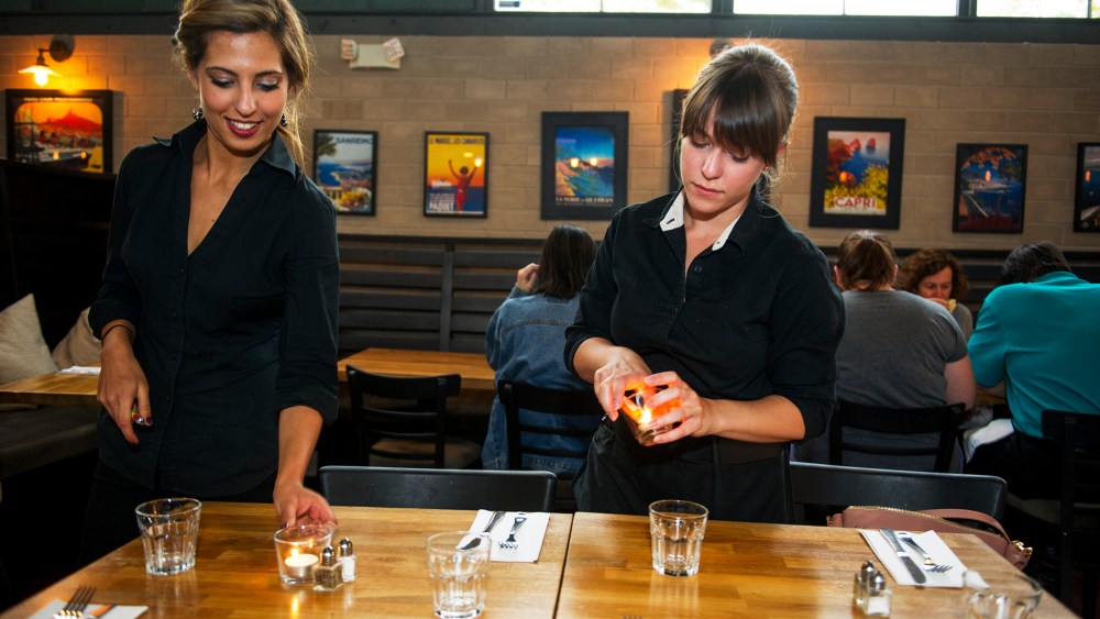 Kristin Ezell lights candles with Lydia Magoura at Mina's Mediterraneo, where she waitresses on May 16, 2014 in Miami Shores, Florida.