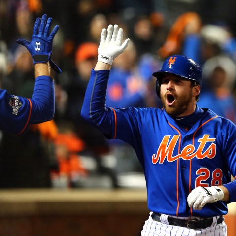 Daniel Murphy #28 of the New York Mets celebrates with his teammates after hitting a two run home run in the first inning against Jake Arrieta #49 of the Chicago Cubs during game two. (Photo by Elsa/Getty)