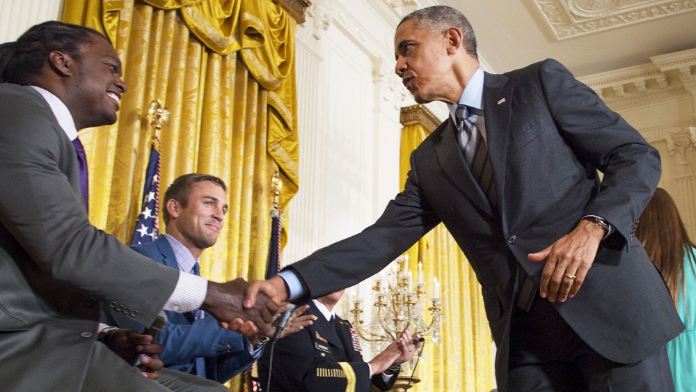 US President Barack Obama shakes hands with panelist and former NFL linebacker LaVar Arrington (L) during the White House Healthy Kids & Safe Sports Concussions Summit, May 29, 2014.
