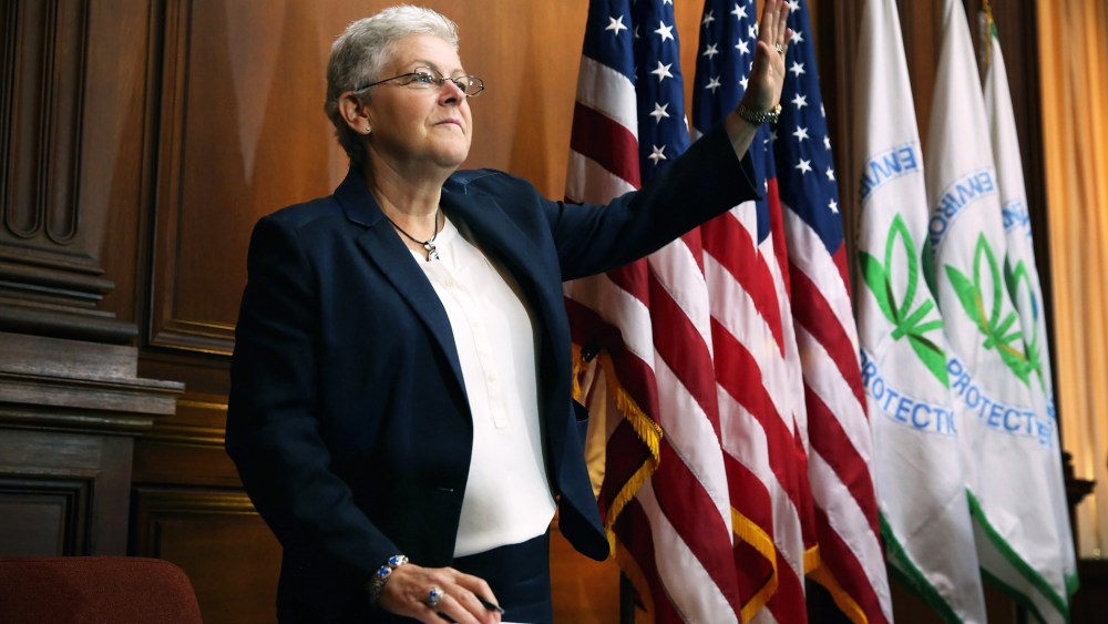 U.S. Environmental Protection Agency Administrator Gina McCarthy waves before signing new regulations for power plants at EPA headquarters June 2, 2014 in Washington, DC.