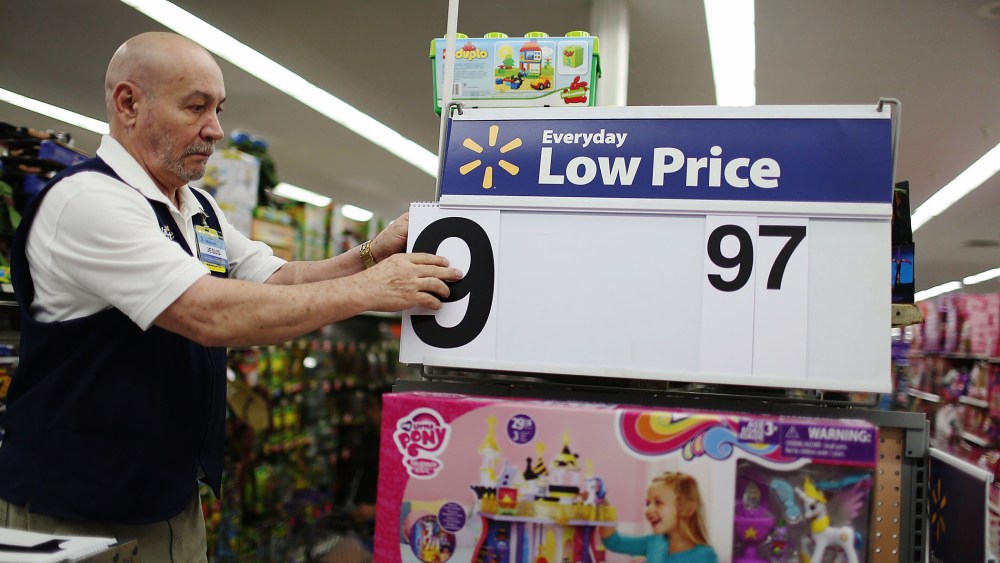Jesus Gutierrez puts a low price dollar sign together at a Walmart store as they prepare for Black Friday shoppers on Nov. 24, 2015 in Miami, Fla. (Photo by Joe Raedle/Getty)
