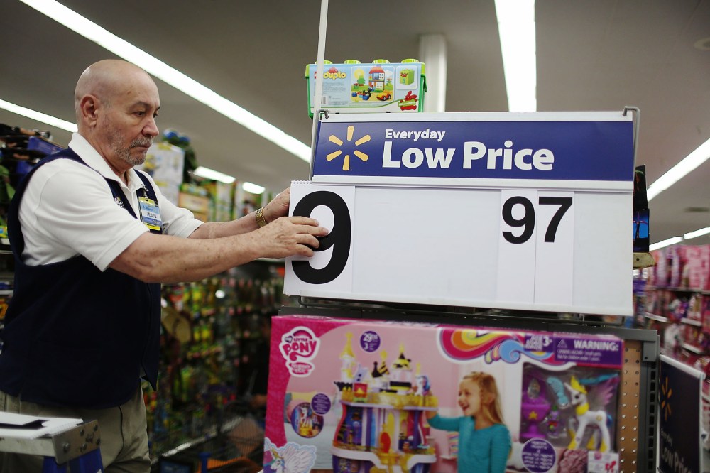 Jesus Gutierrez puts a low price dollar sign together at a Walmart store as they prepare for Black Friday shoppers on Nov. 24, 2015 in Miami, Fla. (Photo by Joe Raedle/Getty)