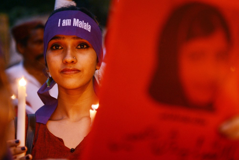 A Pakistani demonstrator carries a candle during a protest against the assassination attempt of child activist Malala Yousafzai. (Asif Hassan/AFP)
