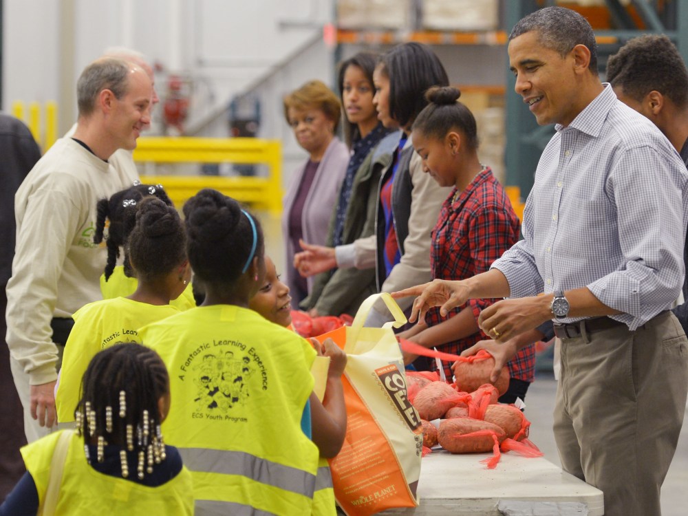 (R to L) US President Barack Obama, daughter Sasha, First Lady Michelle Obama, daughter Malia and mother-in-law Marian Robinson, distribute food at the Capitol Area Food Bank on November 21, 2012, a day ahead of Thanksgiving, in Washington, DC.  (Photo...