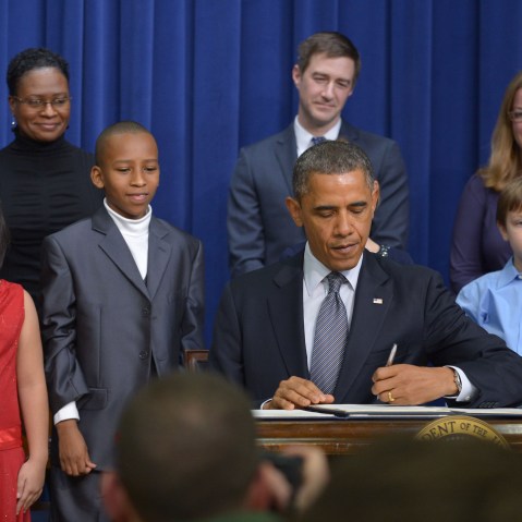 As guests look on, President Barack Obama signs executive actions to curb gun violence at the South Court Auditorium of the Eisenhower Executive Office Building, next to the White House in Washington on January 16, 2013. (Photo by Mandel Ngan/AFP/Getty...