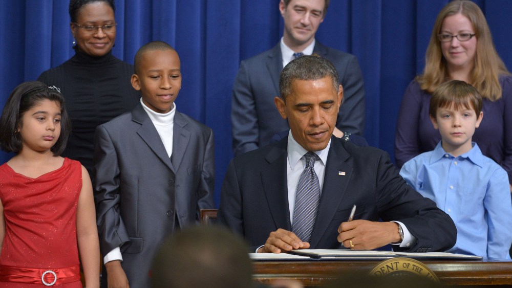 As guests look on, President Barack Obama signs executive actions to curb gun violence at the South Court Auditorium of the Eisenhower Executive Office Building, next to the White House in Washington on January 16, 2013. (Photo by Mandel Ngan/AFP/Getty...