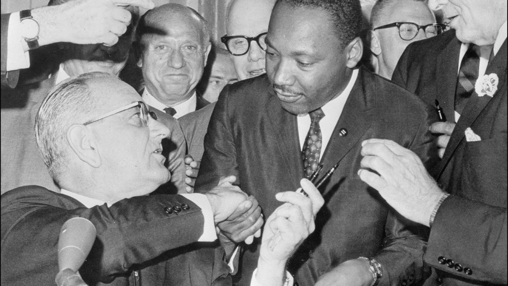 President Lyndon Johnson shakes hands with civil rights leader Martin Luther King Jr. after singing the civil rights bill at the White House in Washington, D.C.