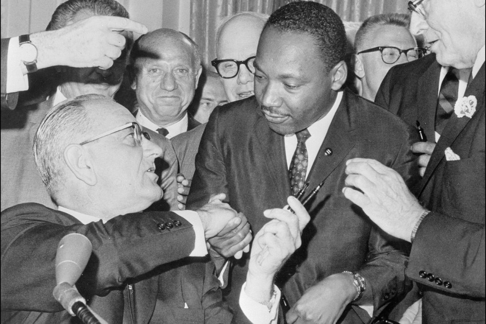 President Lyndon Johnson shakes hands with civil rights leader Martin Luther King Jr. after singing the civil rights bill at the White House in Washington, D.C.