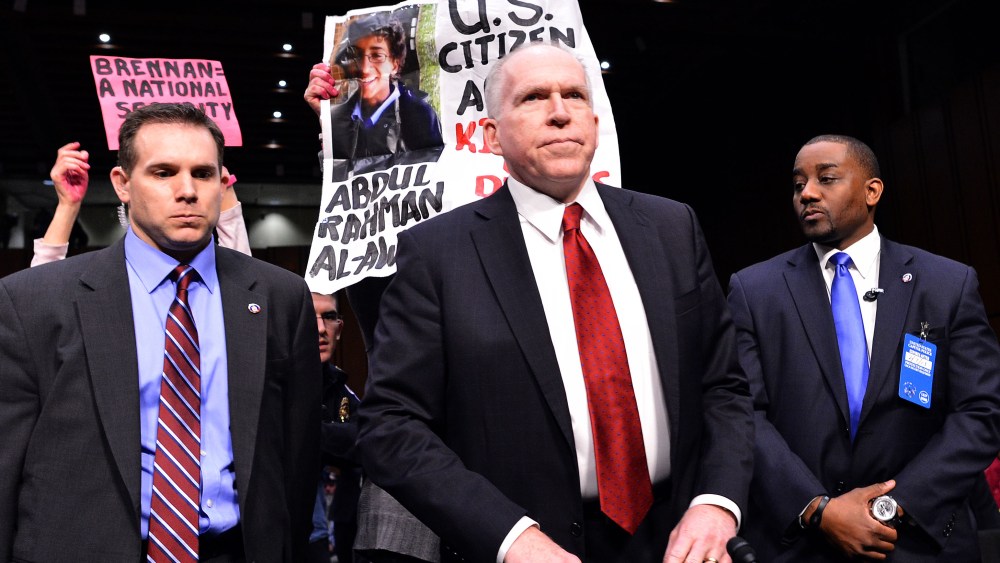 Anti-war protesters (back) shout slogans as John Brennan (C), US President Barack Obama's pick to lead the CIA, arrives to testify before a full committee hearing on his nomination to be director of the Central Intelligence Agency  (CIA) in the Hart...