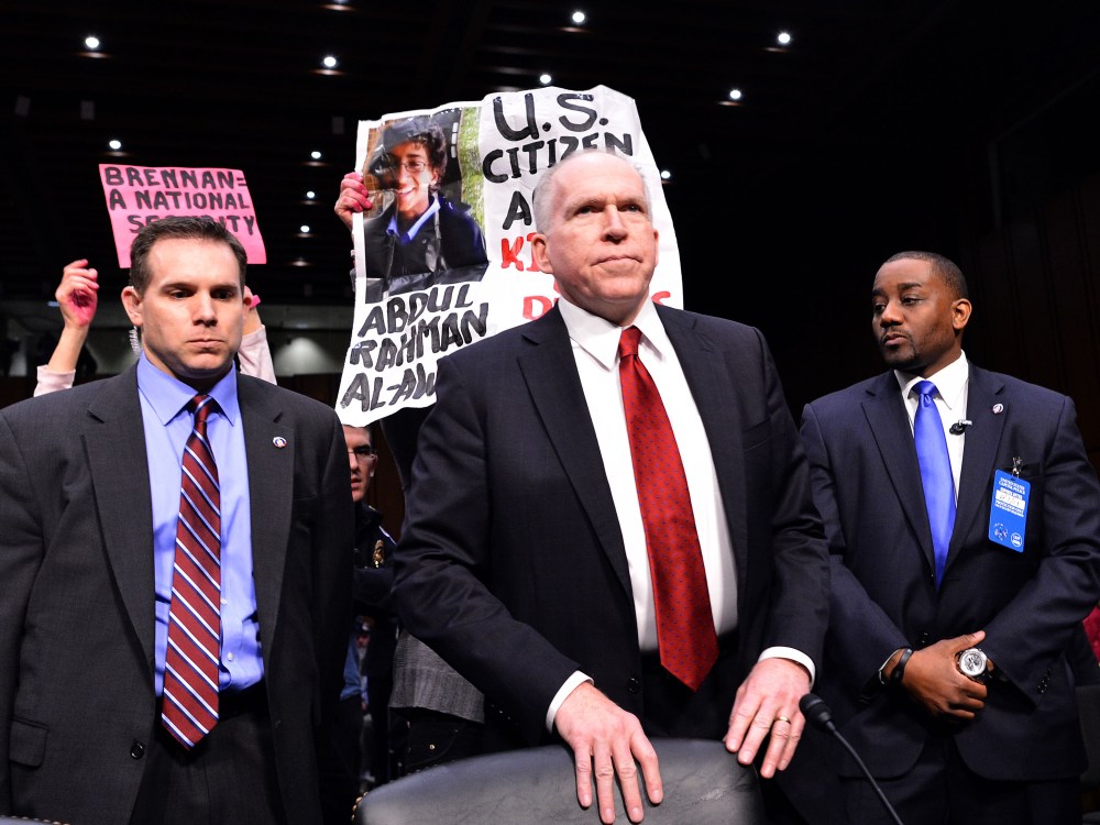 Anti-war protesters (back) shout slogans as John Brennan (C), US President Barack Obama's pick to lead the CIA, arrives to testify before a full committee hearing on his nomination to be director of the Central Intelligence Agency (CIA) in the Hart...