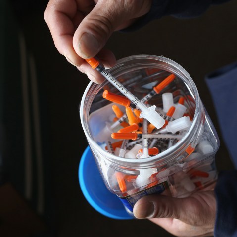 A drug user takes a needle before injecting himself with heroin on March 23, 2016 in New London, CT. (Photo by John Moore/Getty)