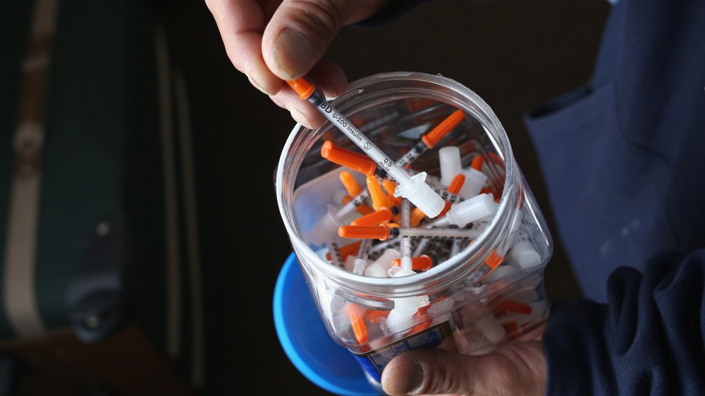 A drug user takes a needle before injecting himself with heroin on March 23, 2016 in New London, CT. (Photo by John Moore/Getty)