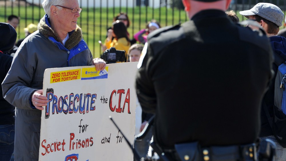 A man holds a poster accusing CIA of torturing Iraqi war prisoners as he protests outside the White House in Washington DC on March 19, 2013, the 10th anniversary of the beginning of the Iraq war. (Photo by Mladen Antonov/AFP/Getty Images)
