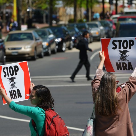 Protesters march while holding placards calling for tighter gun control on April 25, 2013 near McPherson Square in Washington, DC.  The National Rifle Association (NRA) is lobbying against gun reforms laws being debated in the US Congress.  (Photo by...