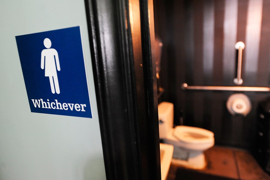 A gender neutral sign is posted outside a bathrooms at Oval Park Grill on May 11, 2016 in Durham, N.C. (Photo by Sara D. Davis/Getty)