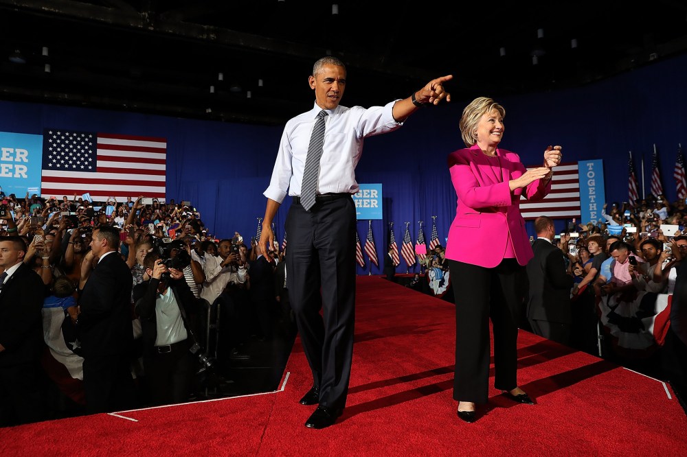 Democratic presidential candidate former Secretary of State Hillary Clinton (R) and U.S. president Barack Obama greet supporters during a campaign rally on July 5, 2016 in Charlotte, N.C. (Photo by Justin Sullivan/Getty)