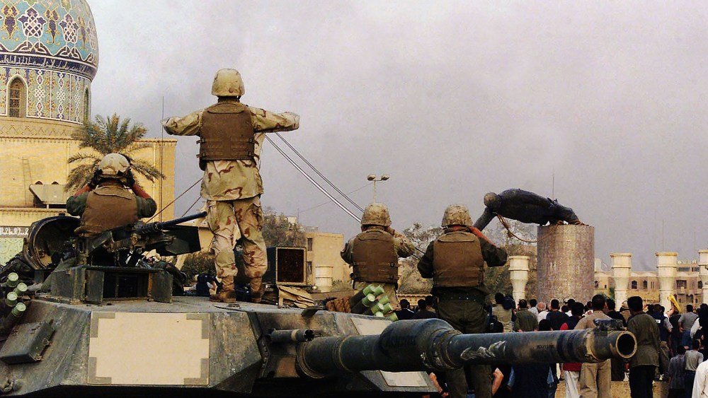 File Photo: U.S marines and Iraqis are seen on April 9, 2003, as the statue of Iraqi dictator Saddam Hussein is toppled at al-Fardous square in Baghdad, Iraq. (Photo by Wathiq Khuzaie /Getty Images, File)