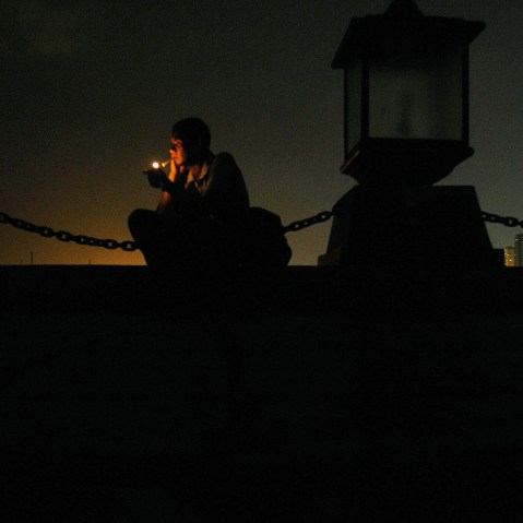 A man lights a cigarette at a seaside park in Manila, Philippines.