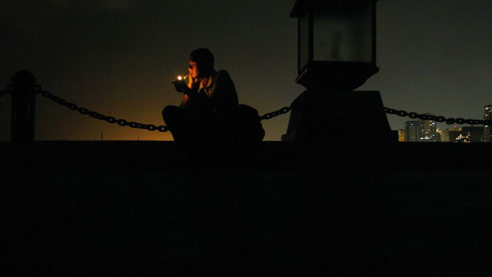 A man lights a cigarette at a seaside park in Manila, Philippines.
